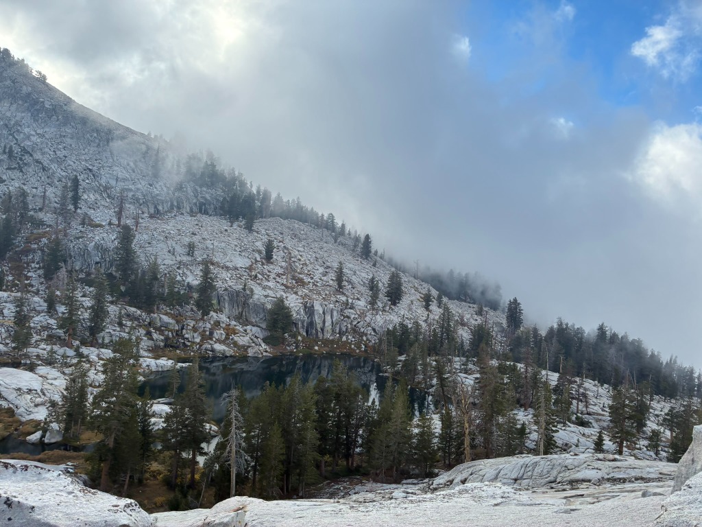 Misty mountain landscape with trees and a lake